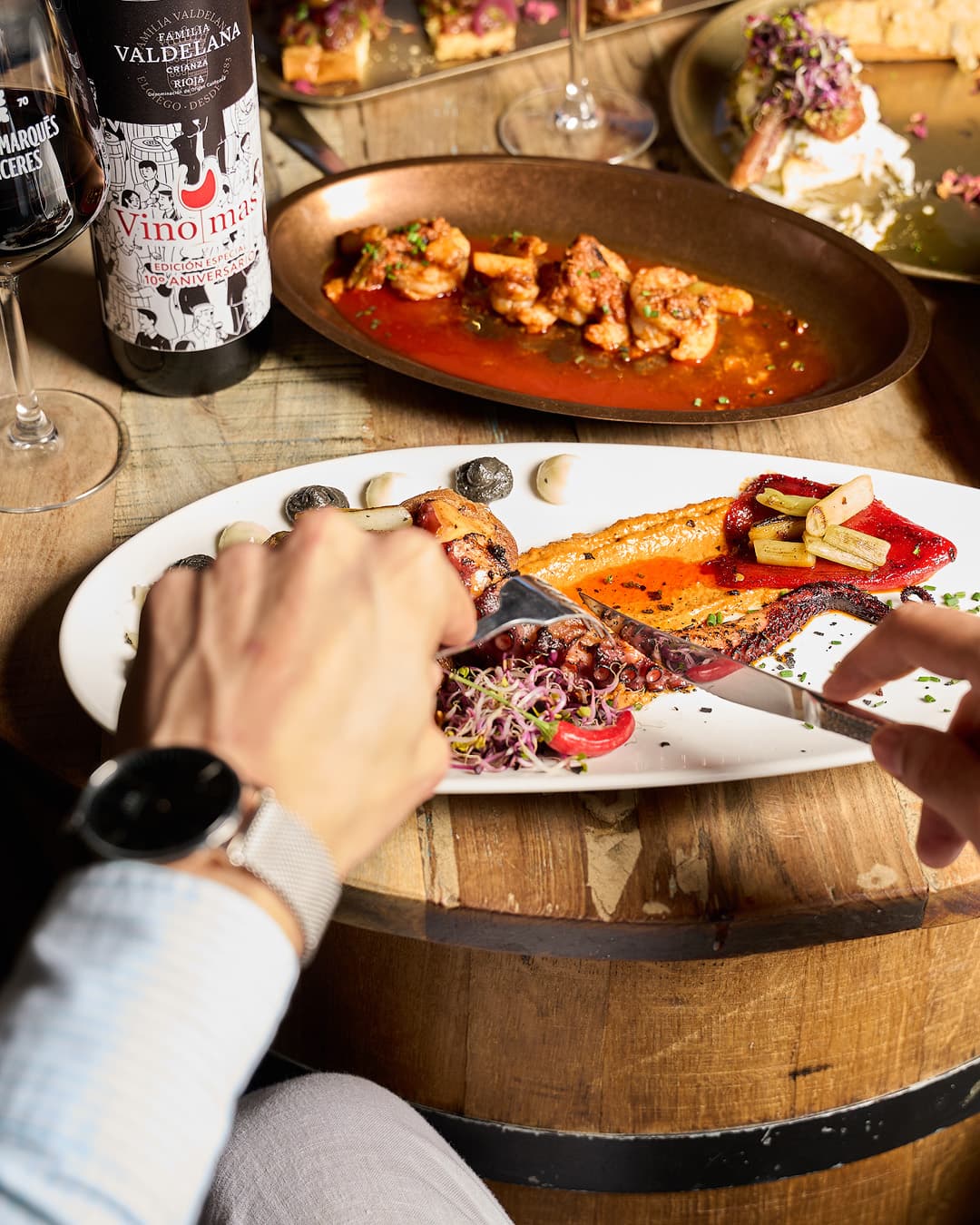 Person enjoying octopus at Vino y Más, Alicante